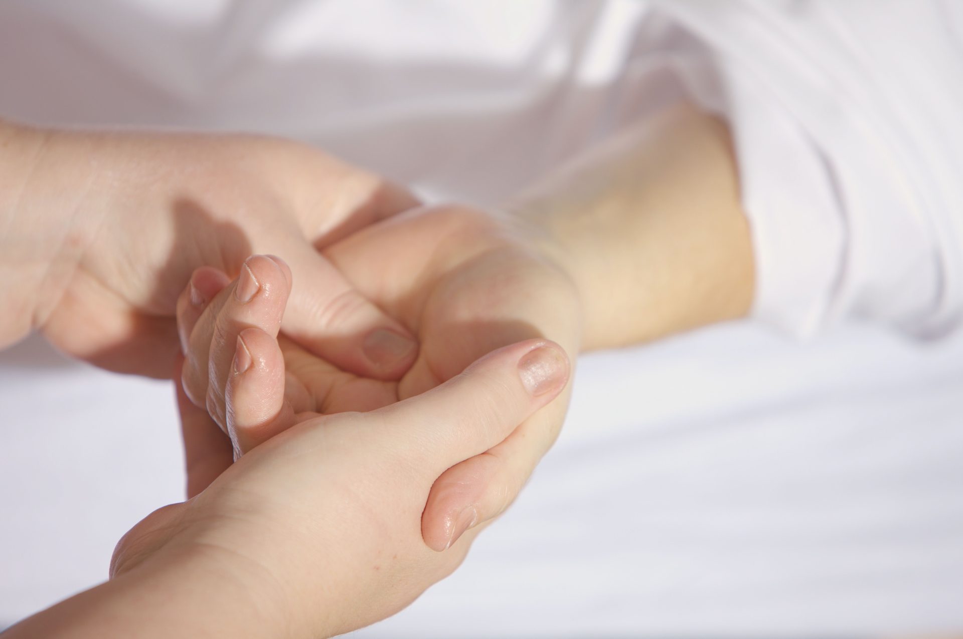 Nahaufnahme einer entspannenden Handmassage mit sanften Berührungen und viel Sorgfalt.